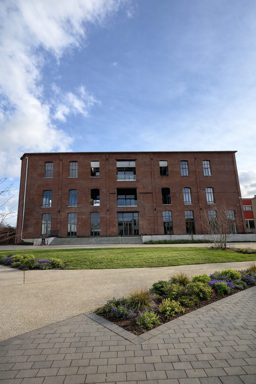 Façade réhabilitée du programme La Lainière sur jardin paysager.